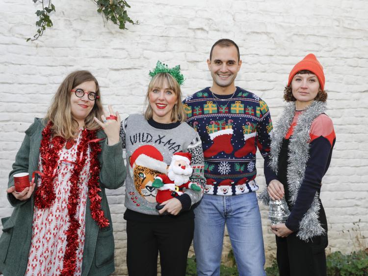 3 femmes et 1 homme en pulls et accessoires de Noël