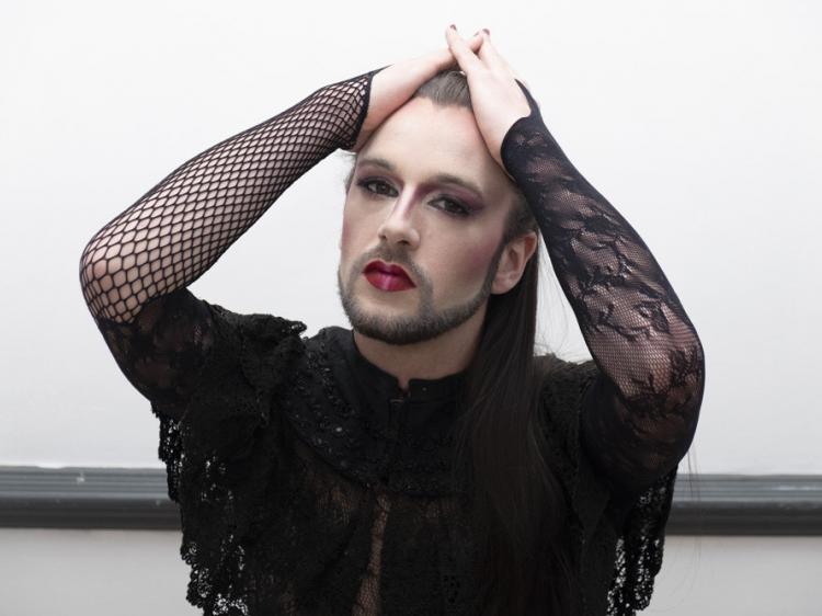 femme avec une barbe qui tire ses cheveux longs en arrière