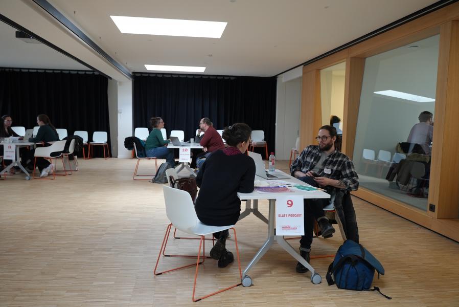 salle avec personnes assises par tables de 4